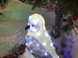 skön vykort med fågel mes flygande ha glas gyllene festlig klot hängande på gren jul träd vinter- i parkera foto