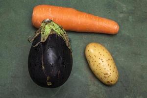 rå aubergine på grön trä bakgrund. foto