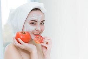 kvinna äta tomat. äter vegetabiliska för friska hud och healt vård i spa salong begrepp foto