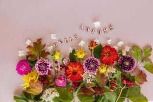 chic höst sammansättning av ljus flerfärgad trädgård blommor och trä- brev med de text -Hallå höst. topp se. platt lägga. beige bakgrund. foto