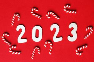 jul sammansättning med godis käppar och siffra 2023 på en röd bakgrund. kopia Plats för text foto