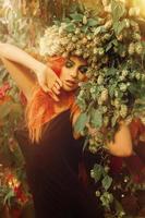 ung sensuell rött hår lady med hopp på huvud och stängd ögon i skog Framställ foto