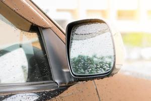 regndroppar på sidospegeln på en bil foto
