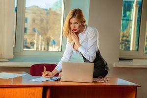företag lady skrivningar dokument och talande telefon i kontor foto