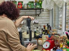 kock blandar de Ingredienser till förbereda de deg i ett elektrisk maskin foto