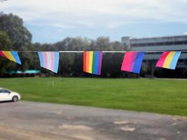 regnbåge flaggor och lgbtq plus flaggor var hängd på tråd mot blå himmel på solig dag, mjuk och selektiv fokus, begrepp för lgbtq plus kön fester i stolthet månad runt om de värld. foto