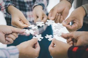 begrepp av upptäckt lösning. stänga upp människor montering kontursåg pussel i arbete möte baner med Lycklig kontor arbetstagare spelar spel under team byggnad aktivitet. foto