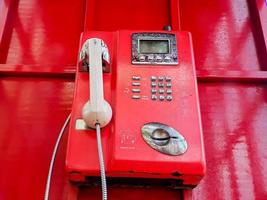 de gammal röd trådbunden telefon i de dåtid, dess tycka om gående tillbaka till de över var människor ofta Begagnade offentlig telefoner. foto
