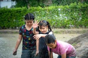 liten flickor ha roligt spelar i de lera i de gemenskap fält foto