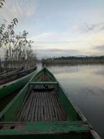traditionell trä- båt flytande på de vattnen av sjö limboto, gorontalo, Indonesien. små trä- roddbåt på en lugna sjö foto