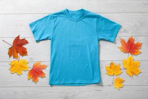 främre visningar av liten pojke i blå t-shirt på vit trä- skrivbord bakgrund. attrapp för design foto