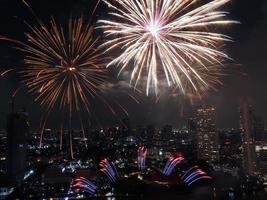 hög vinkel se fantastisk Flerfärgad lång exponering skott av fyrverkeri över chao phraya flod, stadsbild av Bangkok, festival, firande, Lycklig ny år, företag arkitektur. foto