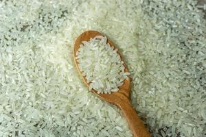 torr ris eller okokt ris. topp vinkel se av rå ris och trä- sked foto