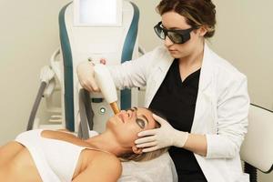 kvinna klient under ipl behandling i en kosmetologi klinik foto