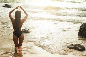 kvinna bär swiming kostym och avkopplande på de tropisk strand foto