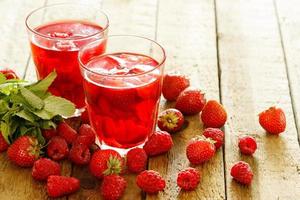 uppfriskande dryck med hallon och jordgubb på trä- tabell foto