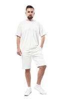 stilig man bär tom vit t-shirt och shorts på vit bakgrund foto