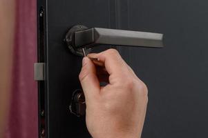 hex nyckel och installation av dörr låsa och hantera, närbild av installation arbete. foto