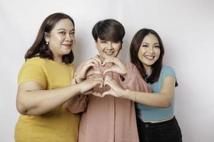 tre asiatisk kvinnor känna Lycklig och en romantisk former hjärta gest uttrycker anbud känslor, stänga vänskap begrepp. foto
