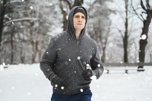 ung joggare man under hans träna i vinter- parkera foto