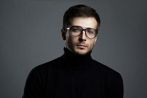 ung intelligent man bär turtleneck och glasögon foto