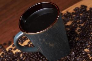 en kopp kaffe med kaffebönor foto