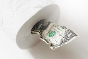 skrynkliga ett dollar räkningen sätta inuti en toalett papper rulla. foto