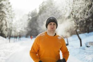 ung joggare man under hans träna i vinter- parkera foto