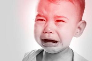 liten gråt bebis lidande från en huvudvärk foto