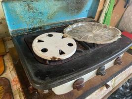gammal smutsig liten två-brännare gas spis för matlagning i en tiggarens bostad foto