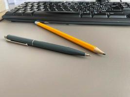 automatisk grön kulpenna penna och skrivning penna på skrivbordet kontor skrivbord med dator tangentbord. företag arbete foto