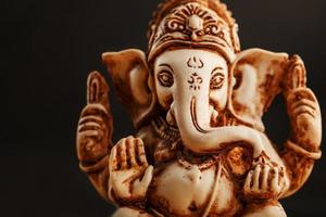 hindu Gud ganesh på en svart bakgrund. staty med rökelse rök arom pinnar foto