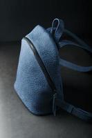 blå ryggsäck tillverkad av äkta läder på en mörk bakgrund, handgjorda. foto