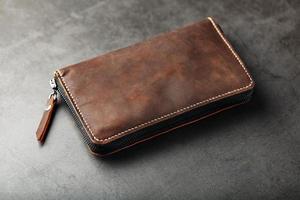 arrangör plånbok tillverkad av brun äkta läder, handgjort på en mörk bakgrund foto