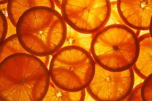 skivor av massa och krydda mogen orange med bakgrundsbelysning som en textural bakgrund, de substrat. full skärm, närbild foto