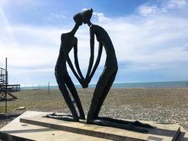 abstrakt statyer, små arkitektonisk former av människor i kärlek i de form av en knästående knä på de batumi primorsky boulevard eller batumi strand. georgien, batumi, april 17, 2019 foto