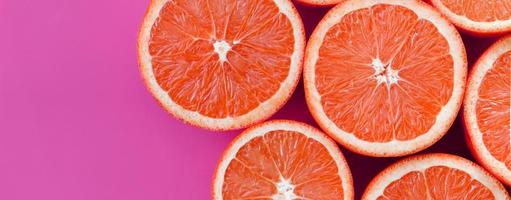 topp se av en flera grapefrukt skivor på ljus bakgrund i lila Färg. en mättad citrus- textur bild foto