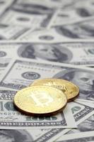 gyllene bitcoins lögn på en massa av dollar räkningar. de begrepp av höjning de pris av bitcoin relativ till de oss dollar foto