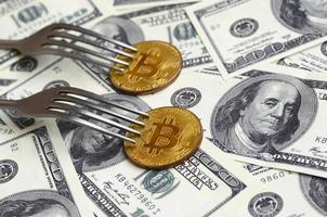 bitcoin få ny hård gaffel förändra, fysisk gyllene kryptovaluta mynt under de gaffel på de dollar bakgrund. blockchain transaktion systemet kris begrepp foto