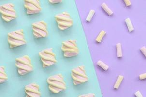 färgrik marshmallow lagd ut på violett och blå papper bakgrund. pastell kreativ texturerad mönster. minimal foto