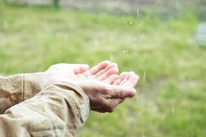 öppen palmer under de regn, närbild. händer samla vatten under de regn. njut av de regn. rensning under en regnstorm. be till Gud be för regn foto