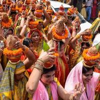 New Delhi, Indien 3 april 2022 - kvinnor med kalash på huvudet under jagannath-templet mangal kalash yatra, indiska hinduistiska hängivna bär jordkrukor som innehåller heligt vatten med en kokosnöt på toppen foto