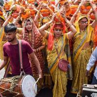 New Delhi, Indien 3 april 2022 - kvinnor med kalash på huvudet under jagannath-templet mangal kalash yatra, indiska hinduistiska hängivna bär jordkrukor som innehåller heligt vatten med en kokosnöt på toppen foto