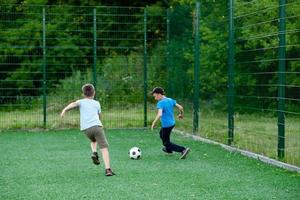 barn spela fotboll i de gård, på de gräsmatta foto