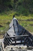 gammal bruten båt med svart fågel. plats - rajbari, bangladesh. datum - 17 november 2022. foto
