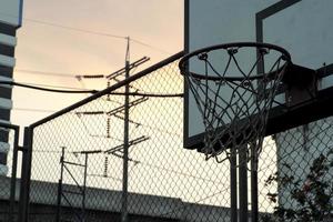 hög vinkel se av gammal basketboll ring med de skymning himmel bakgrund foto