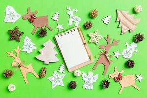 jul grön bakgrund med Semester leksaker och dekorationer. topp se av anteckningsbok. Lycklig ny år begrepp foto