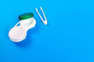 behållare för Kontakt linser, pincett på blå bakgrund foto