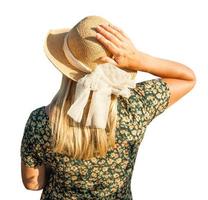 Söt caucasian utomhus flicka bär sundress och hatt vänd bort från kamera på vit bakgrund. foto