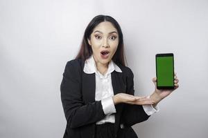 överraskad asiatisk affärskvinna bär svart kostym som visar kopia Plats på henne smartphone, isolerat förbi vit bakgrund foto